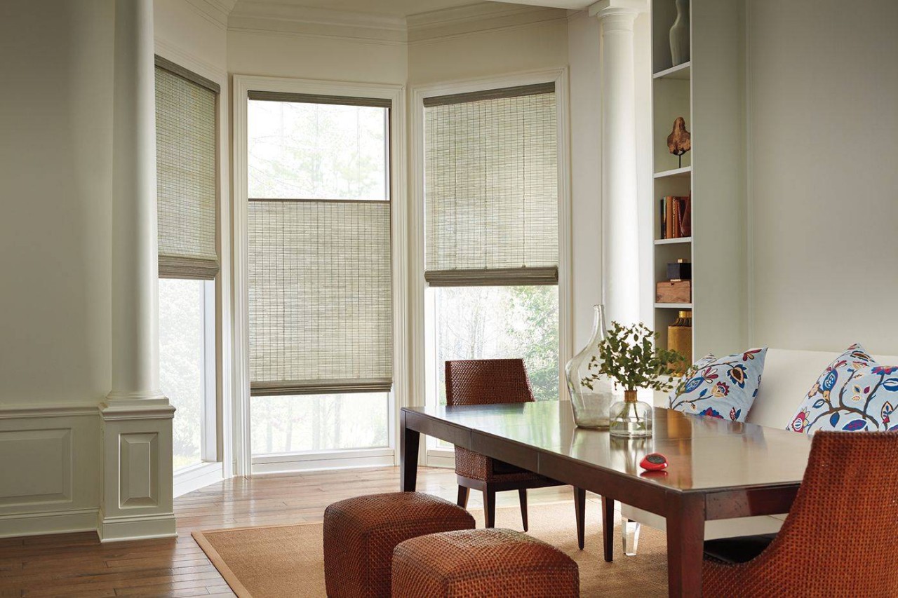 Home dining room with a bay window outfitted with Hunter Douglas Provenance® Woven Wood Shades near Fort Mill, SC